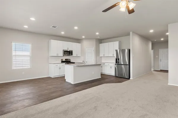 a view of a kitchen with refrigerator and white cabinets