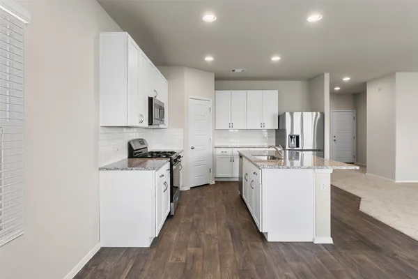 an empty room with chandelier fan and windows