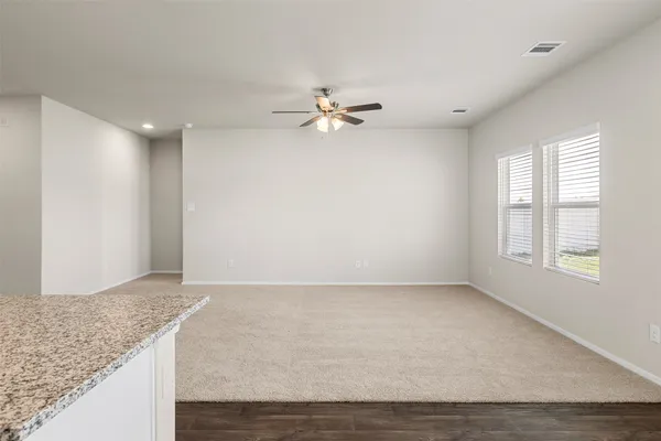 an empty room with a window and a ceiling fan