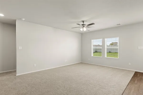 an empty room with windows and fan