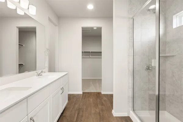 a bathroom with a double vanity sink a mirror and a shower