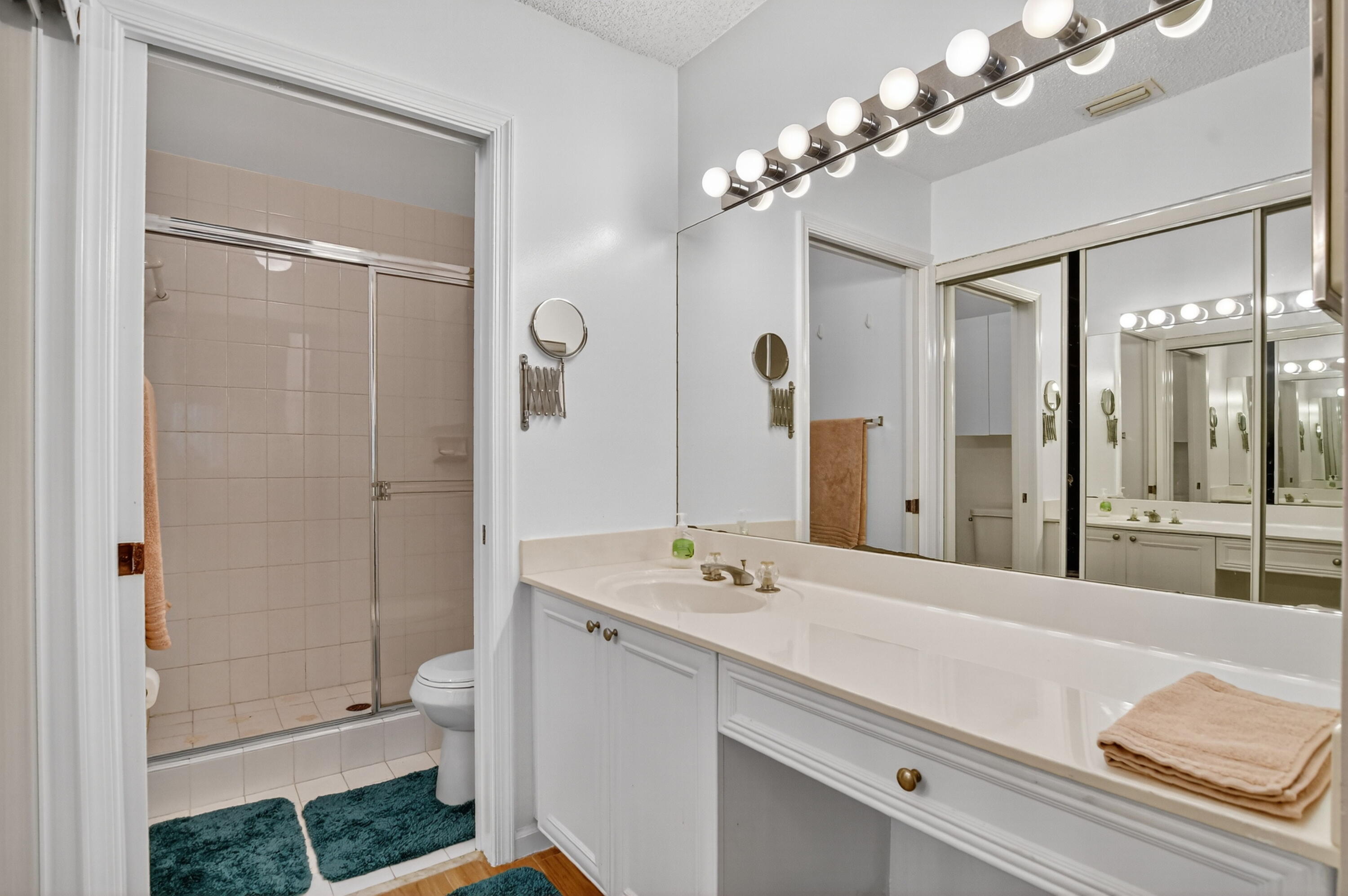 380 Northwest 67th Street, Unit 207 Boca Raton, FL 33487 - Photo 14 of 34 a bathroom with a double vanity sink mirror and shower