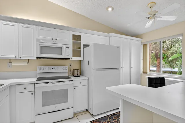 a kitchen with white cabinets and white appliances