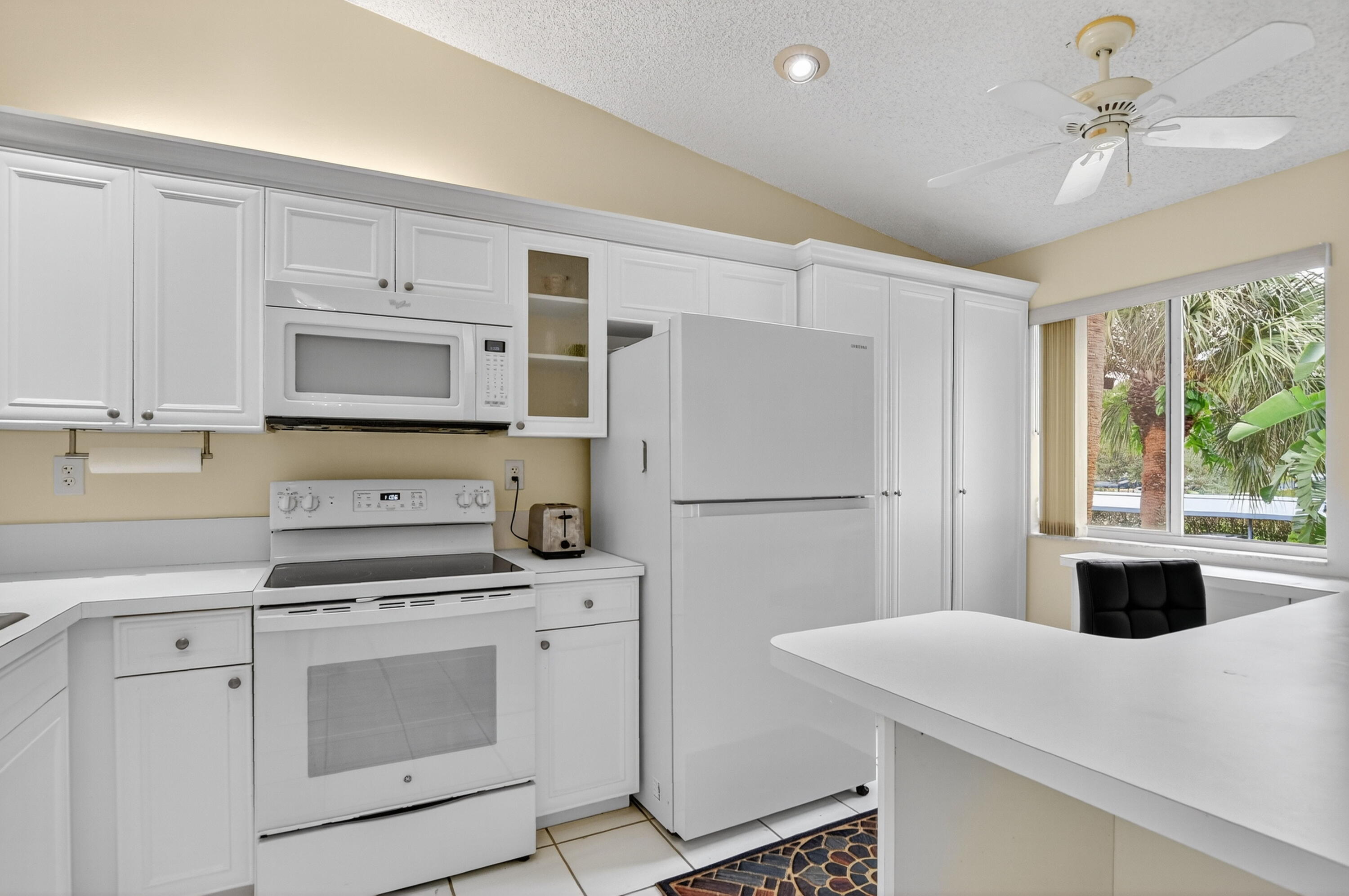 380 Northwest 67th Street, Unit 207 Boca Raton, FL 33487 - Photo 2 of 34 a kitchen with white cabinets and white appliances