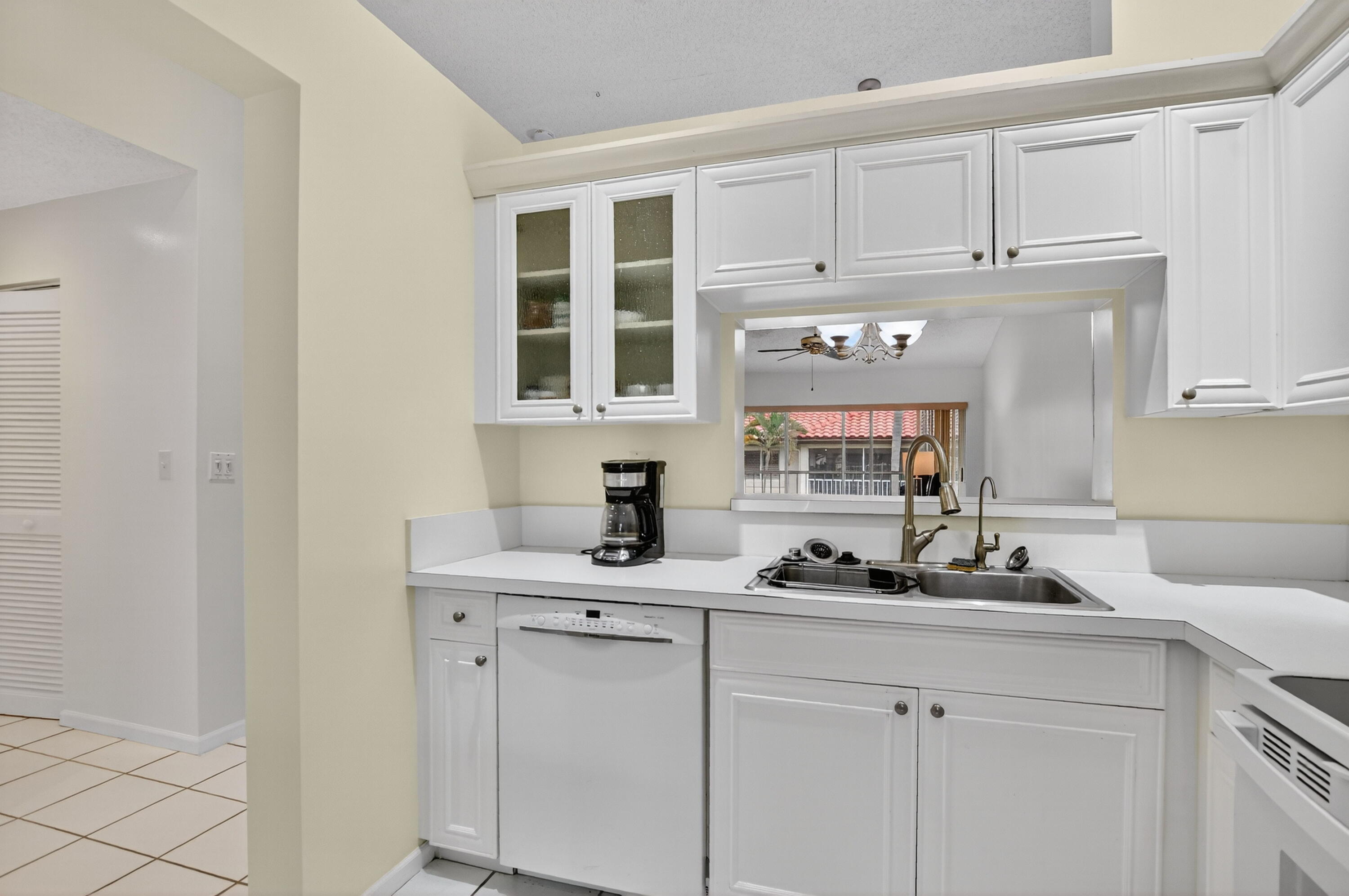 380 Northwest 67th Street, Unit 207 Boca Raton, FL 33487 - Photo 4 of 34 a kitchen with white cabinets and a sink