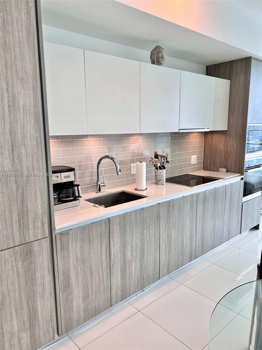 2900 Northeast 7th Avenue, Unit 2708 Miami, FL 33137 - Photo 9 of 25 a kitchen with a sink a stove and cabinets