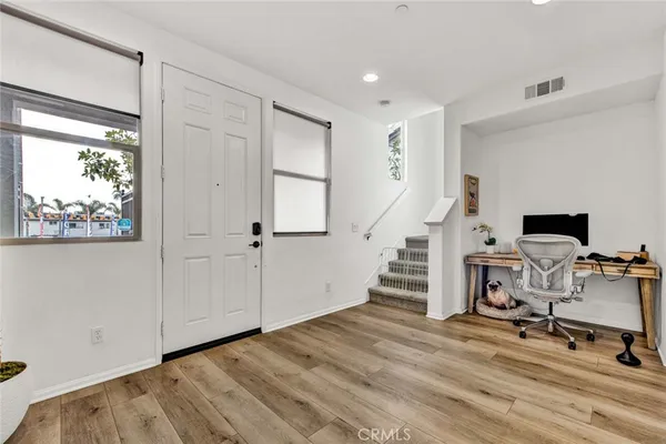 a view of a workspace with wooden floor and white walls