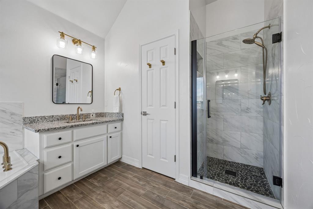 9217 Inverness Drive Rowlett, TX 75089 - Photo 22 of 40 Walk-In Shower with Frameless Glass — The updated shower features a tiled surround, frameless glass, and a tiled shower pan for a clean, modern finish.