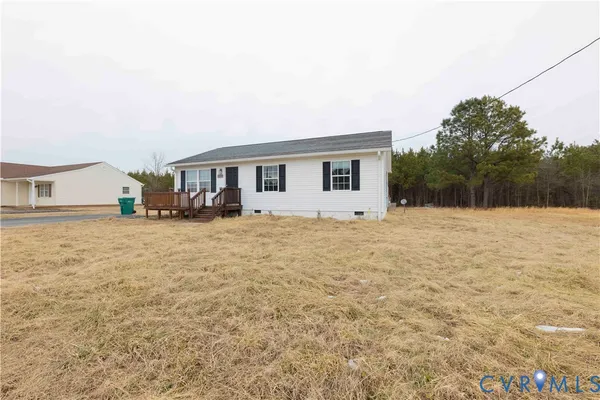 a view of house with yard and trees in the background