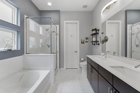 a bathroom with a tub sink shower and mirror