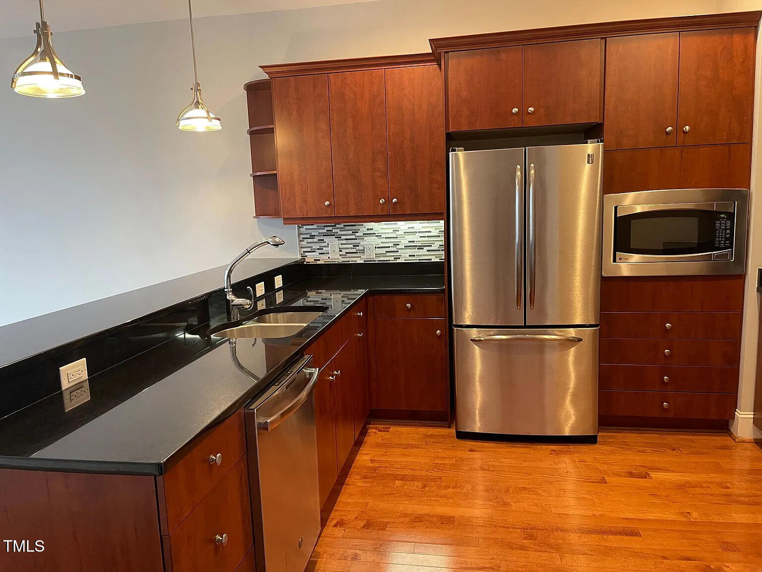 400 West North Street, Unit 634 Raleigh, NC 27603 - Photo 8 of 9 a kitchen with granite countertop a refrigerator a stove and a microwave