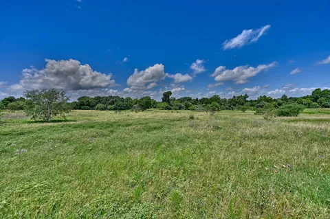 a view of a big yard with a house in the background
