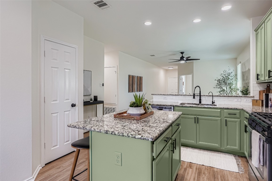 a kitchen with kitchen island granite countertop a sink and cabinets