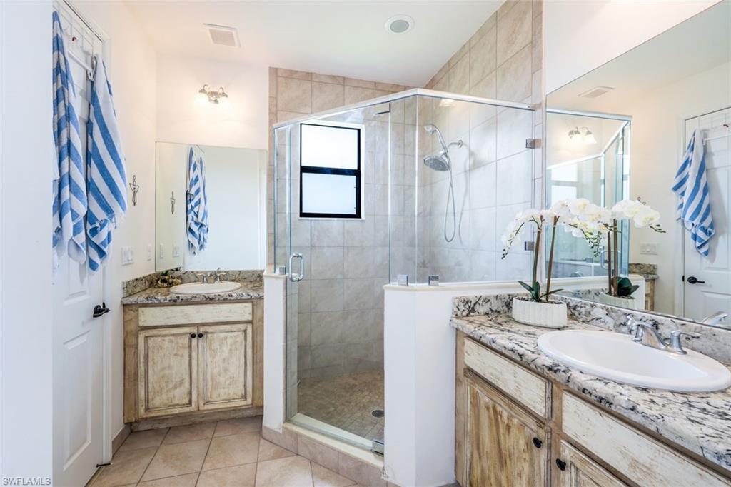 5459 Useppa Drive Ave Maria, FL 34142 - Photo 13 of 21 a bathroom with a granite countertop sink a mirror a vanity and a shower