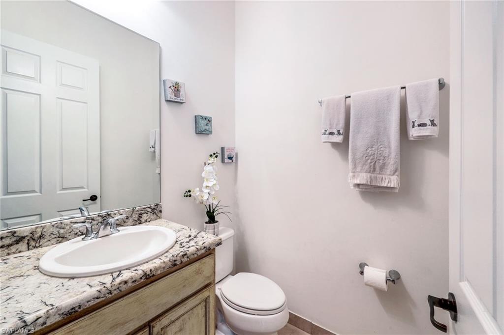5459 Useppa Drive Ave Maria, FL 34142 - Photo 15 of 21 a bathroom with a granite countertop sink a toilet and a mirror