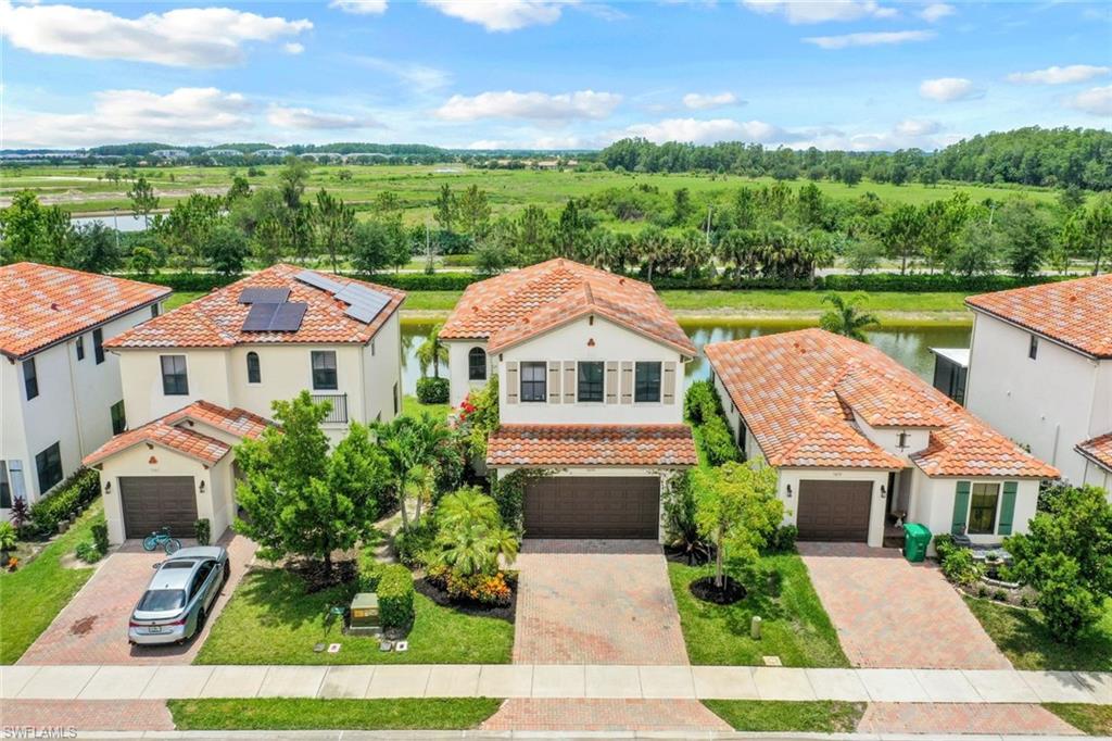 5459 Useppa Drive Ave Maria, FL 34142 - Photo 17 of 21 a front view of a house with a yard and potted plants