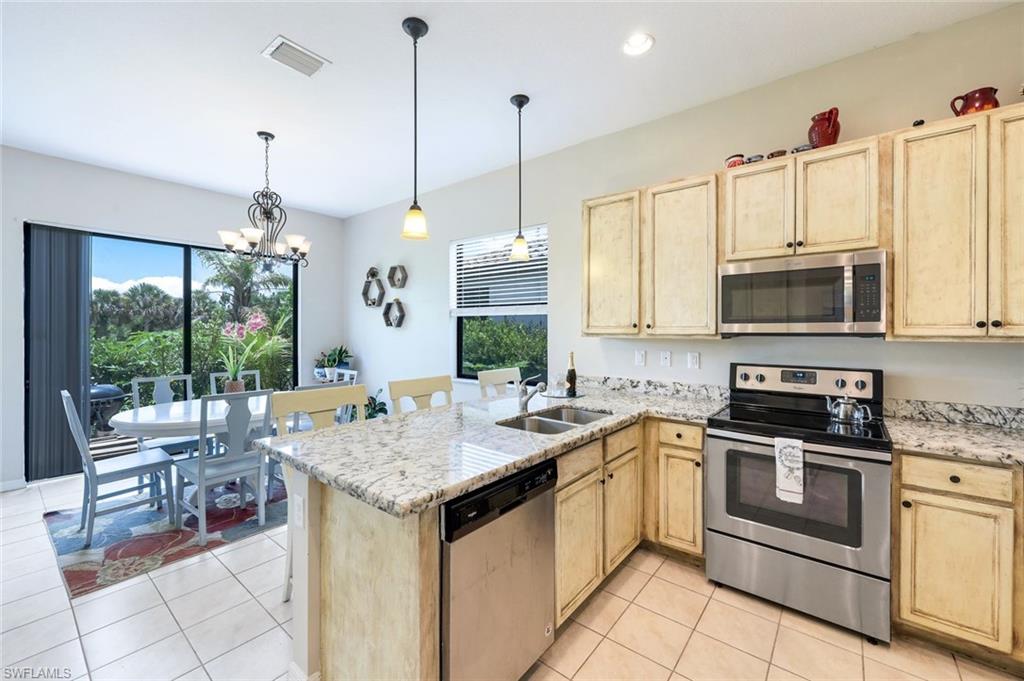 5459 Useppa Drive Ave Maria, FL 34142 - Photo 2 of 21 a kitchen with a sink stove and microwave