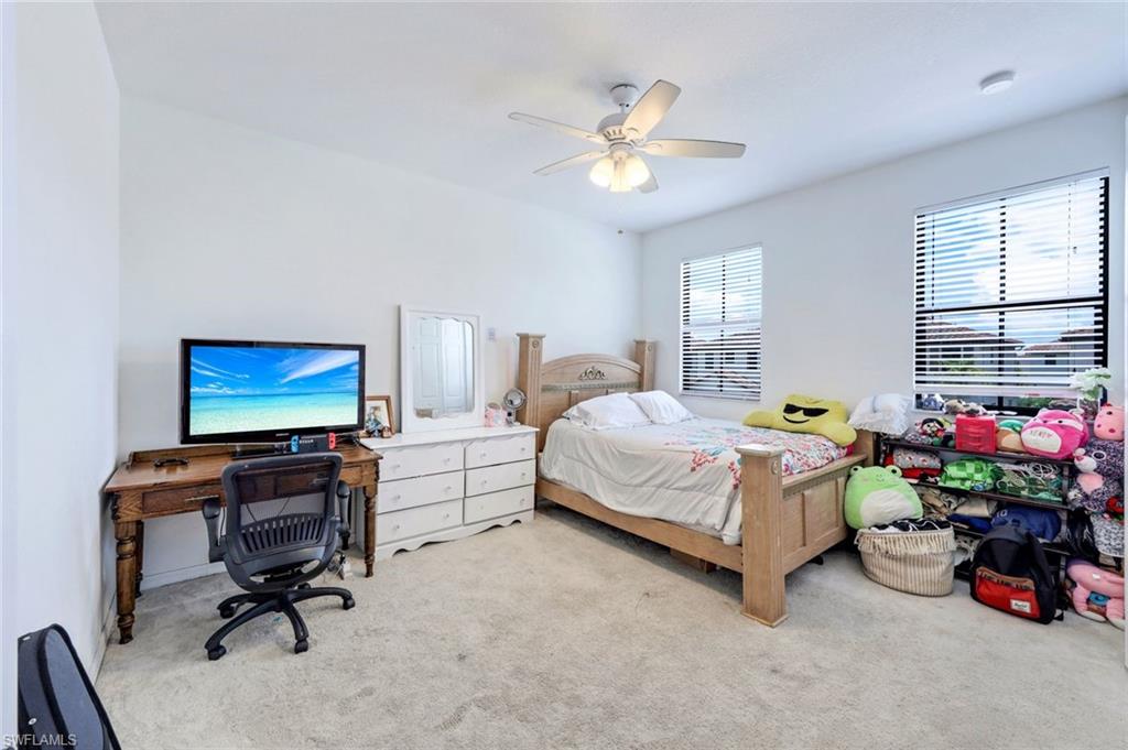 5459 Useppa Drive Ave Maria, FL 34142 - Photo 9 of 21 a bedroom with a bed and a chandelier