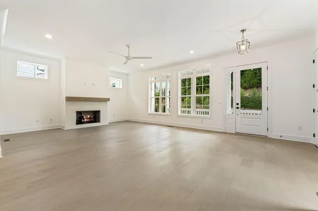 an empty room with windows and fireplace