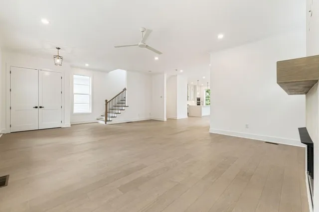 an empty room with windows and fireplace