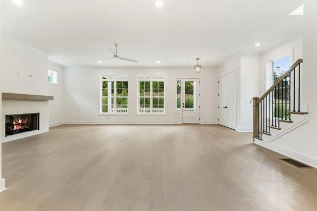 a view of an empty room with a window and wooden floor