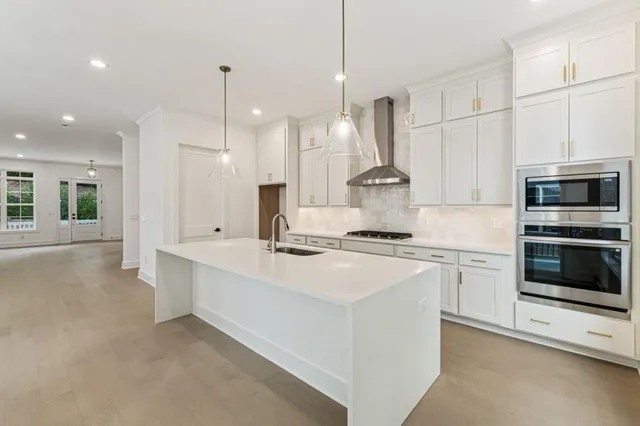 a kitchen with stainless steel appliances granite countertop a sink a stove and a refrigerator