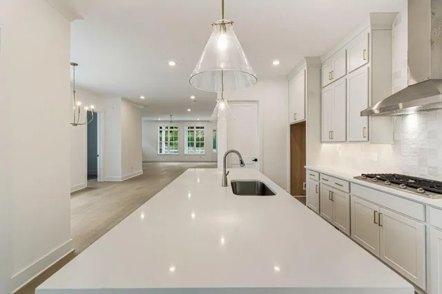 a kitchen with a stove a chimney a sink and cabinets