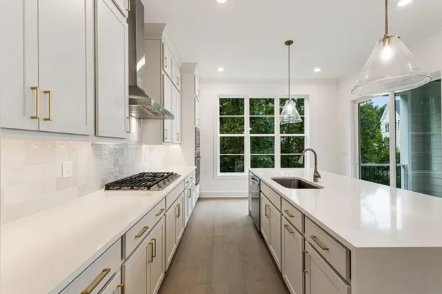 a kitchen that has a sink a stove and a refrigerator