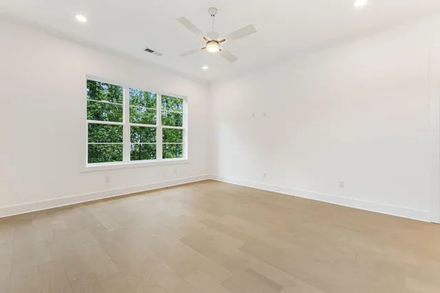 an empty room with an entryway and fan
