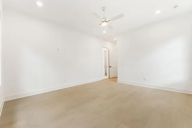 an empty room with windows closet and chandelier fan