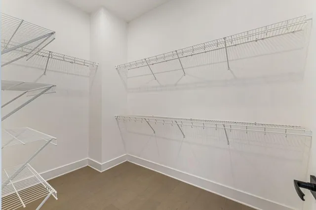 an empty room with windows closet and chandelier fan