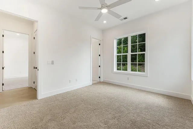 a view of a white house next to a yard