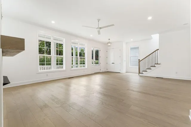 an empty room with windows and fireplace