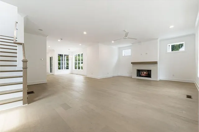 an empty room with windows and fireplace