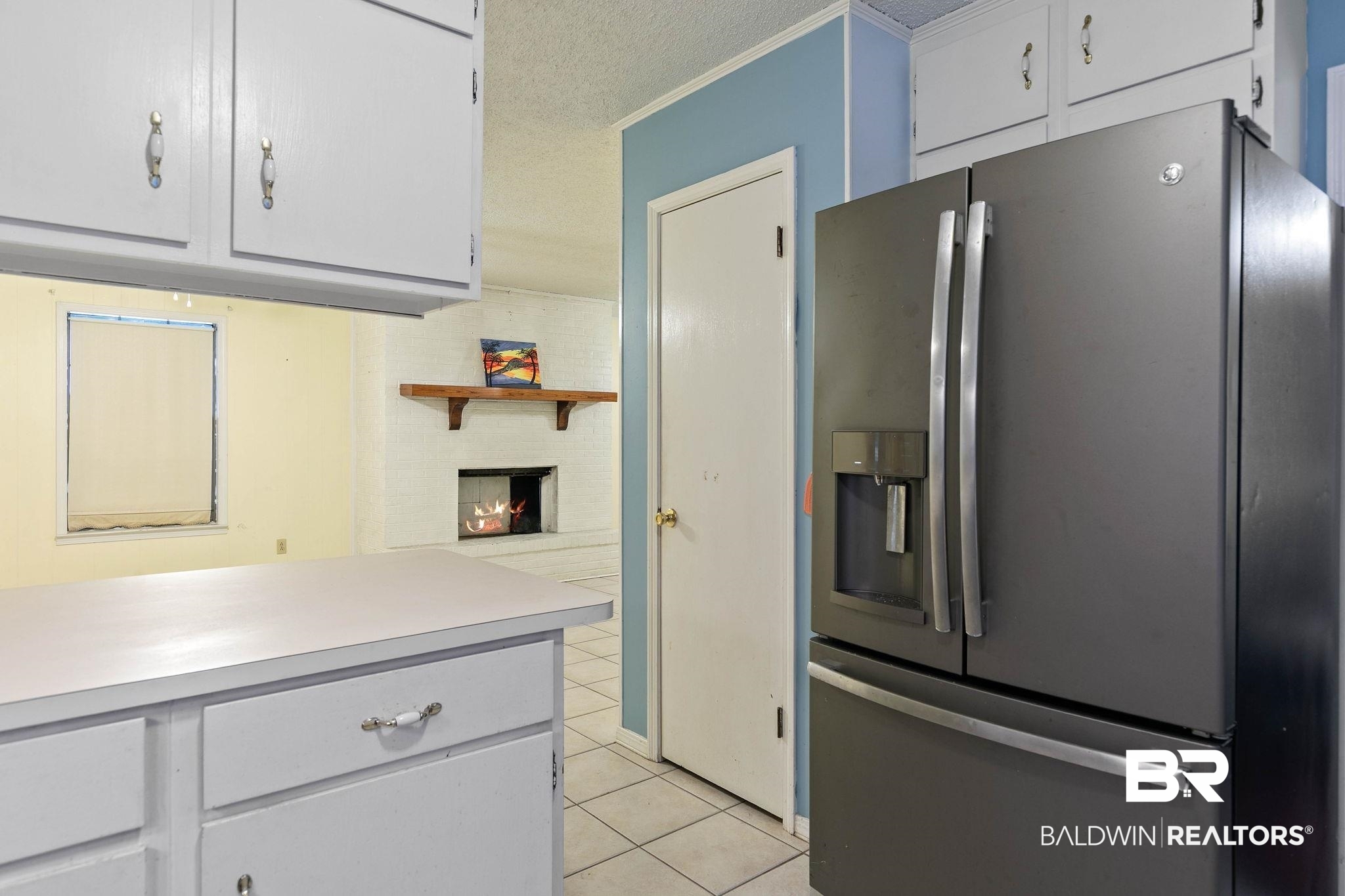 13653 Roberts Road Loxley, AL 36551 - Photo 14 of 33 Kitchen featuring white cabinetry, a counter-depth refrigerator with a built-in ice and water dispenser, and tiled flooring