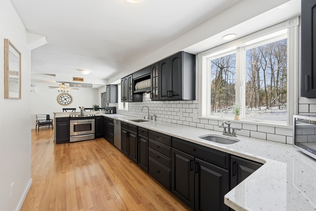 429 Moore Street Ludlow, MA 01056 - Photo 20 of 41 a kitchen with stainless steel appliances a sink dishwasher a stove top oven a refrigerator with wooden floor