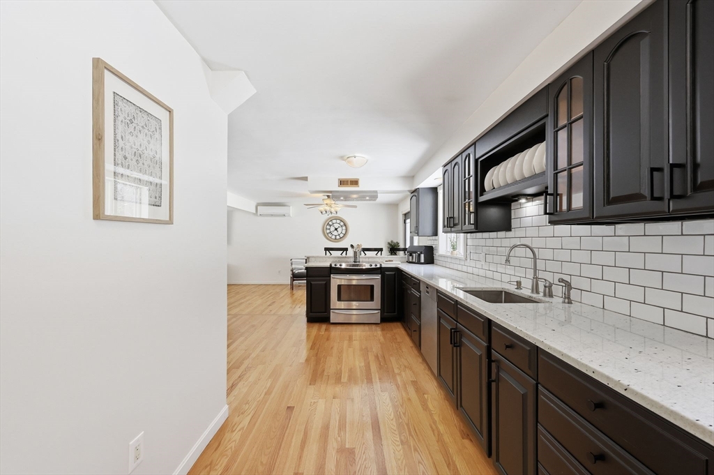429 Moore Street Ludlow, MA 01056 - Photo 21 of 41 a large kitchen with stainless steel appliances granite countertop a stove a sink dishwasher and a microwave oven with wooden cabinets