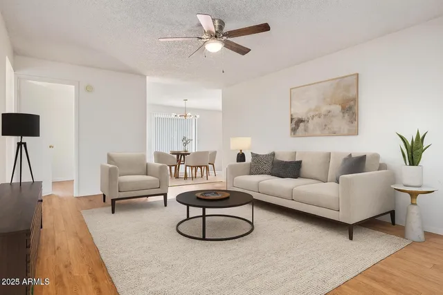 a living room with furniture a rug and a ceiling fan