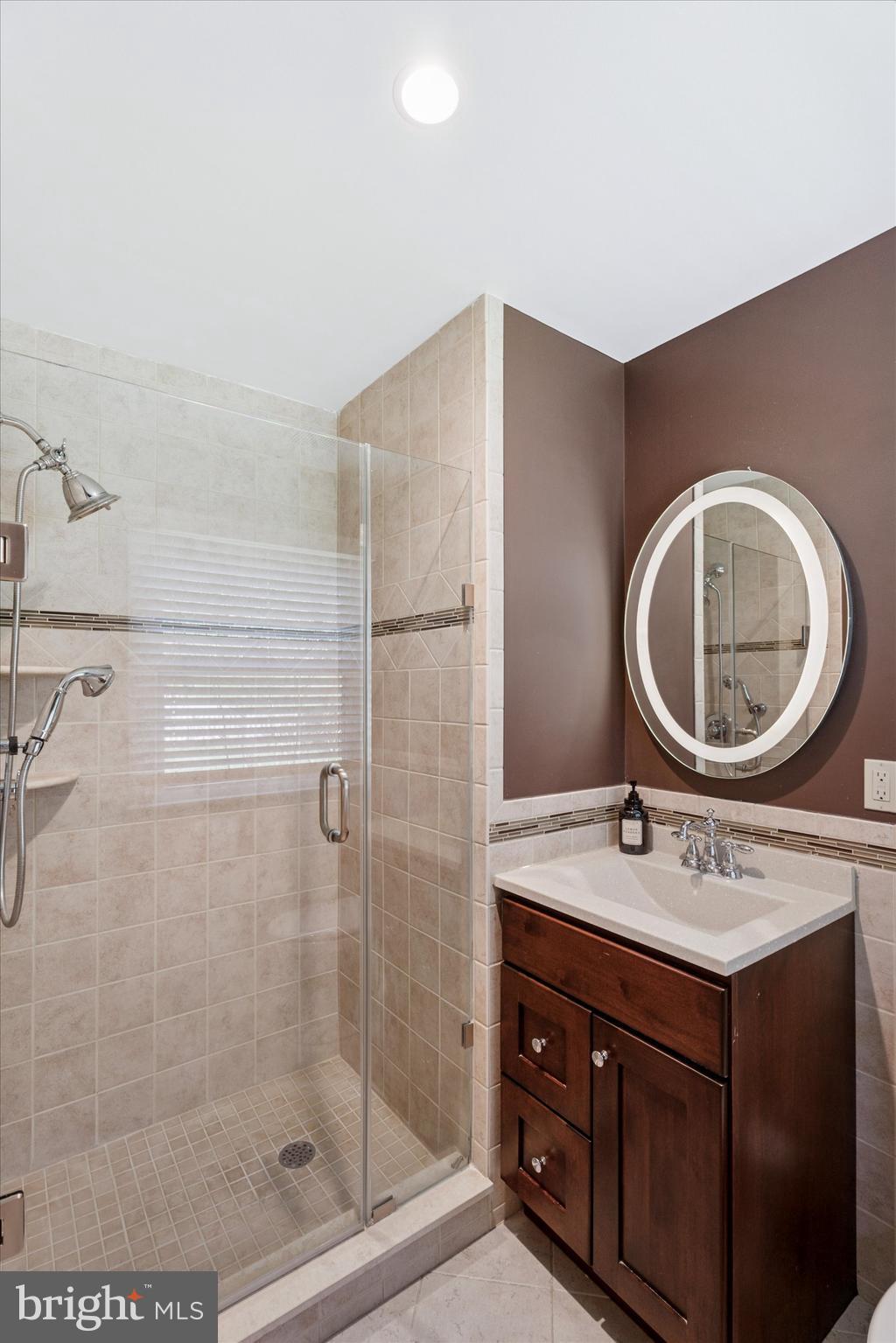 317 Hilltop Road Paoli, PA 19301 - Photo 14 of 25 a bathroom with a sink a mirror and a shower