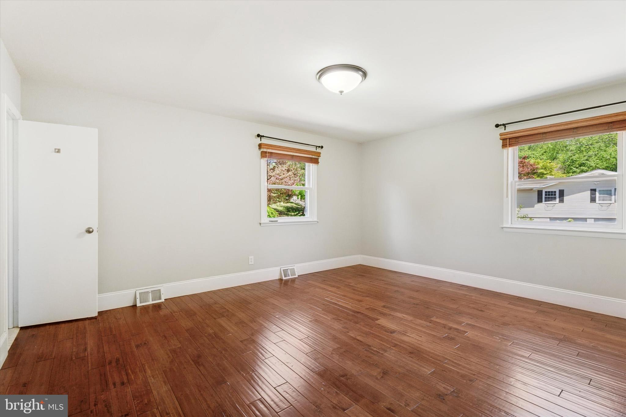 317 Hilltop Road Paoli, PA 19301 - Photo 10 of 25 an empty room with wooden floor and windows