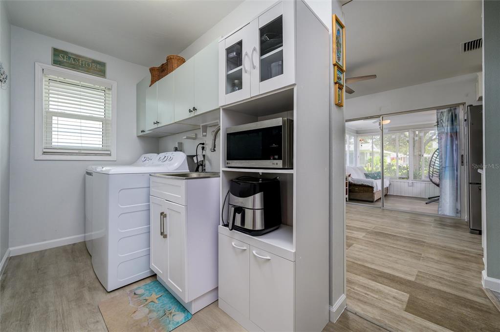 1472 Queen Anne Drive Palm Harbor, FL 34684 - Photo 14 of 34 a kitchen with a sink dishwasher and a fireplace with wooden floor