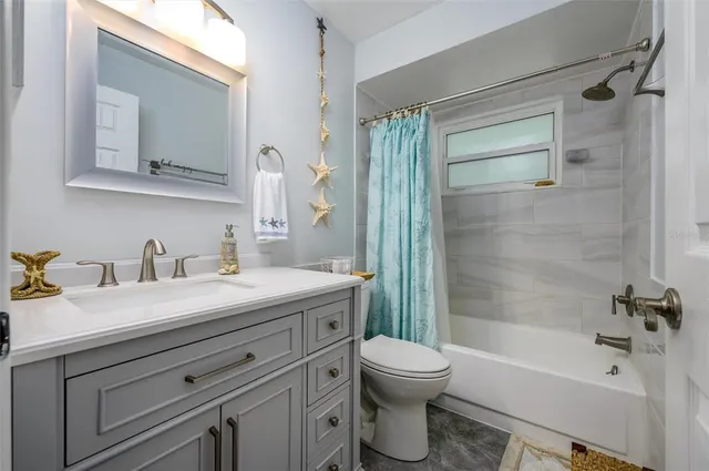 a bathroom with a granite countertop sink toilet a mirror and shower