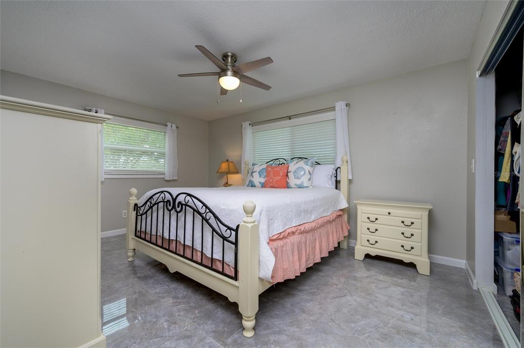 1472 Queen Anne Drive Palm Harbor, FL 34684 - Photo 18 of 34 a bedroom with a bed and a ceiling fan in it