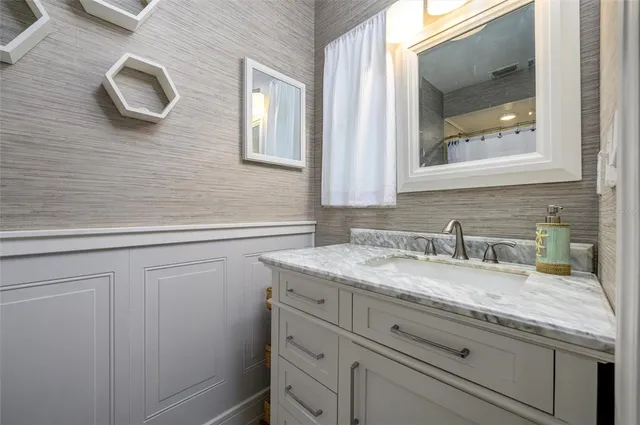 a bathroom with a granite countertop sink and a mirror