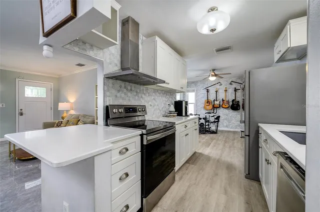 a kitchen with stainless steel appliances a sink stove and refrigerator