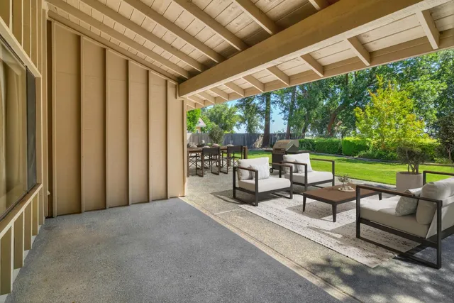 a view of chairs and table in patio with yard