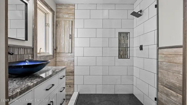 a bathroom with a granite countertop bathtub and shower