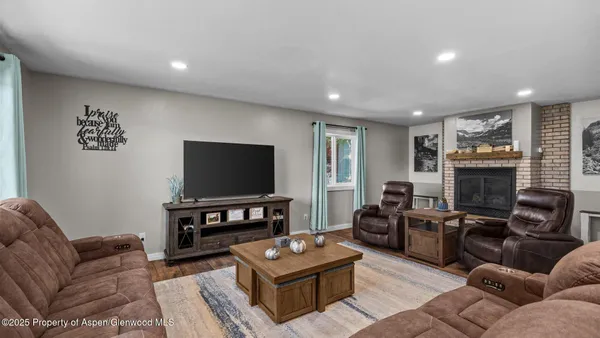 a living room with furniture a flat screen tv and a fireplace