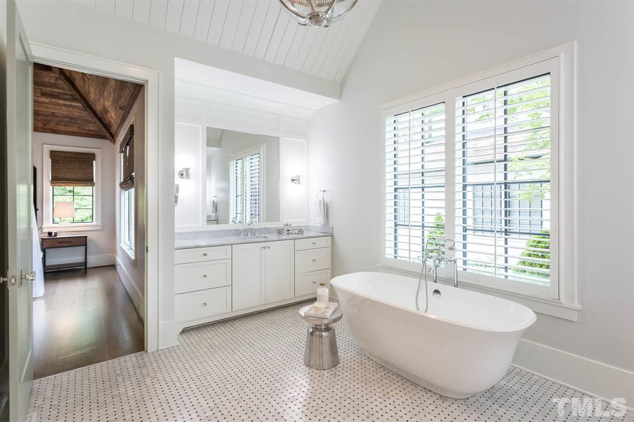 1613 Ridge Road Raleigh, NC 27607 - Photo 20 of 30 a spacious bathroom with a bathtub double vanity and a window
