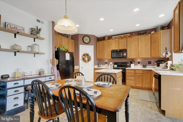 a kitchen with stainless steel appliances granite countertop a stove a sink a microwave a refrigerator and cabinets